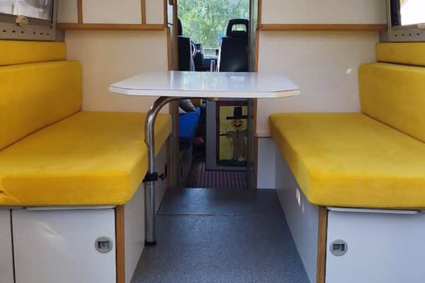 Intérieur de van aménagé avec banquettes jaunes