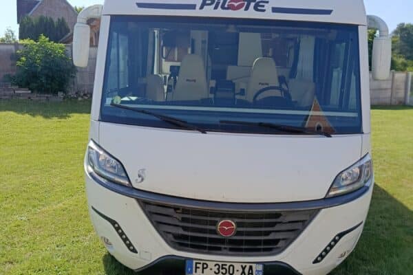 Camping-car Pilote blanc stationné sur pelouse