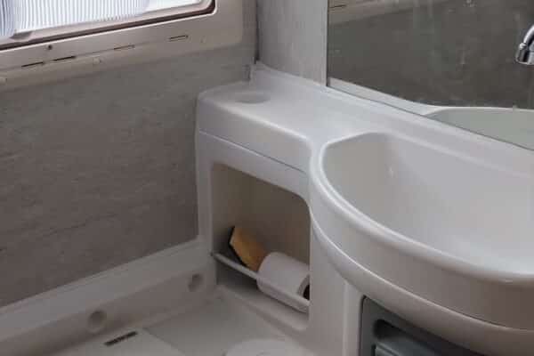Petite salle de bain de camping-car avec toilettes et lavabo