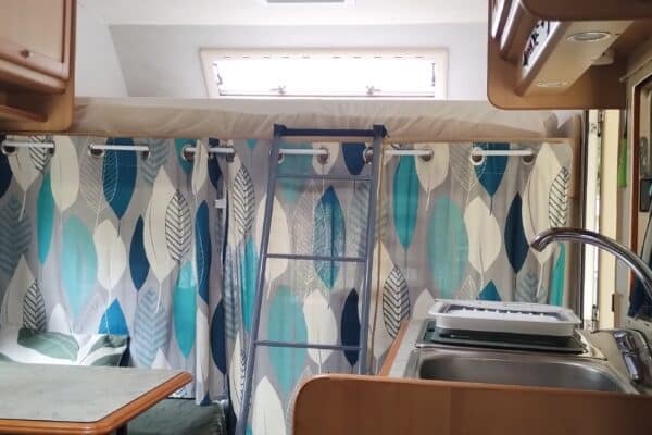 Intérieur de camping-car avec lit superposé et cuisine