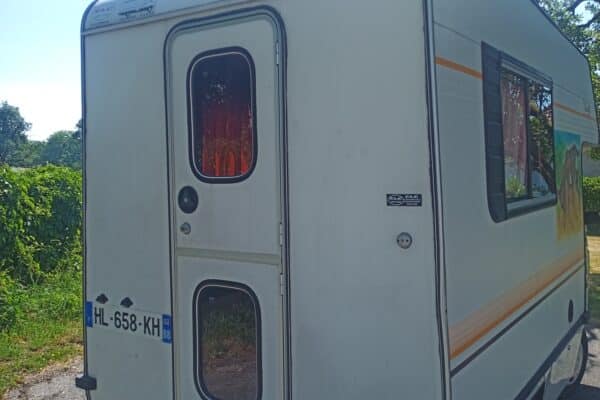 Caravane blanche stationnée au bord de route
