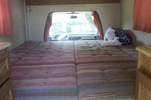 Intérieur de camping-car avec lit et rideaux roses