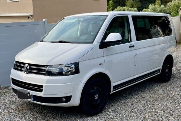 Fourgon Volkswagen blanc stationné sur gravier