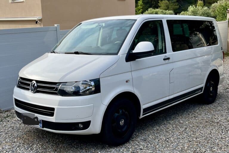 Fourgon Volkswagen blanc stationné sur gravier