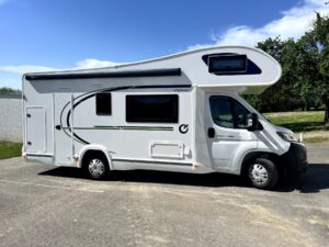 Camping-car blanc stationné sous ciel bleu