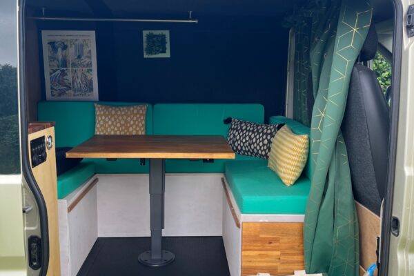 Intérieur aménagé d’un van avec banquettes et table
