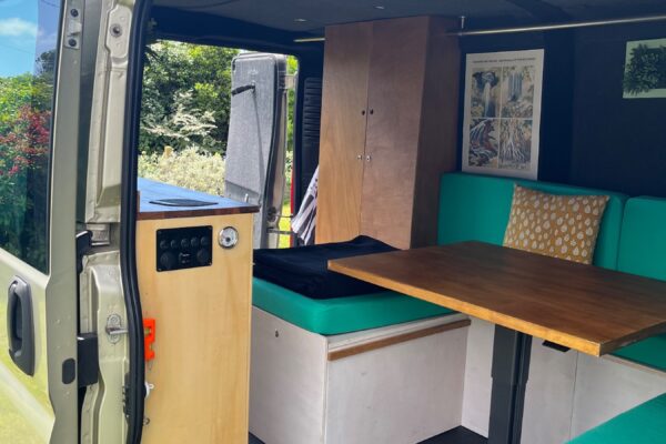 Intérieur aménagé d’un van avec banquettes vertes