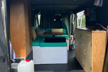 Intérieur aménagé d’un van avec banquette et cuisine