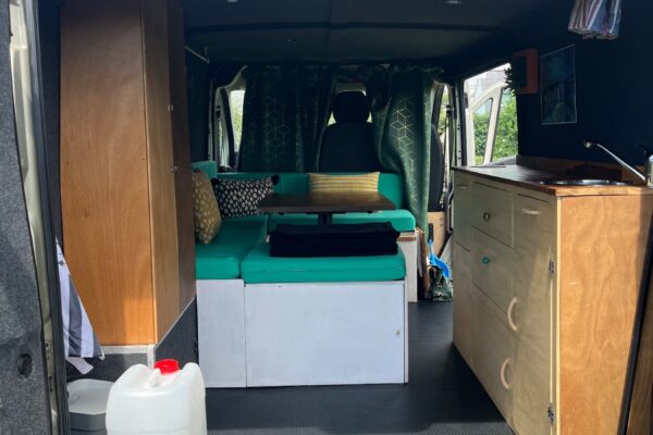 Intérieur aménagé d’un van avec banquette et cuisine