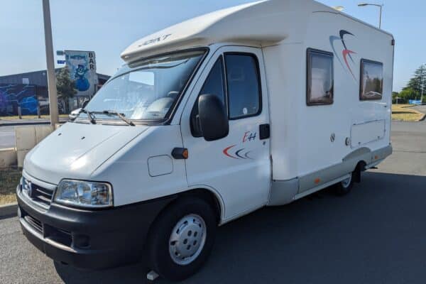 Camping-car blanc stationné en zone commerciale