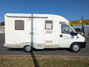 Camping-car blanc stationné près d'une station de lavage