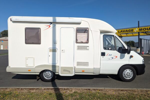 Camping-car blanc stationné près d'une station de lavage