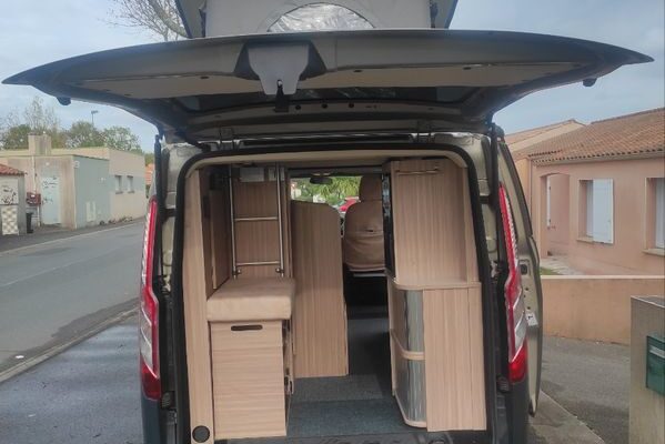 Intérieur aménagé d’un van avec meubles en bois