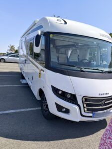 Camping-car Rapido blanc stationné sur parking ensoleillé