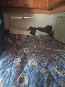 Lit double dans camping-car avec couette bleue