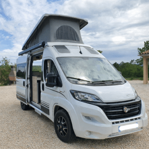 Van aménagé blanc avec toit relevable ouvert