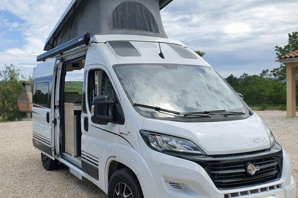 Van aménagé blanc avec toit relevable ouvert