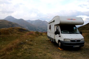 Camping-car stationné en montagne sous ciel nuageux