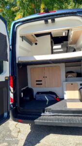 Intérieur aménagé d’un van avec lit et rangements
