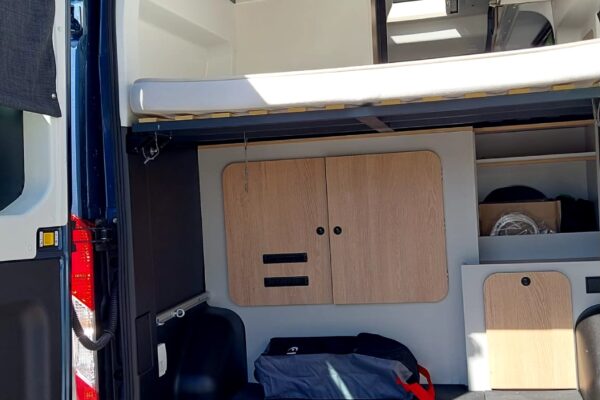Intérieur aménagé d’un van avec lit et rangements