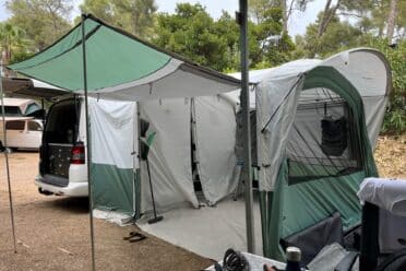 Van aménagé avec auvent et tente au camping