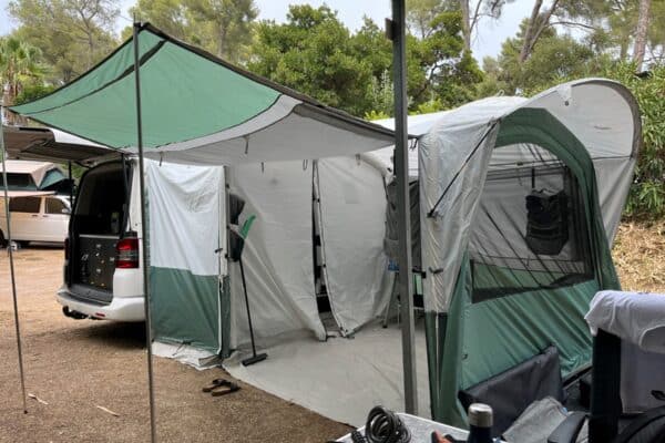 Van aménagé avec auvent et tente au camping