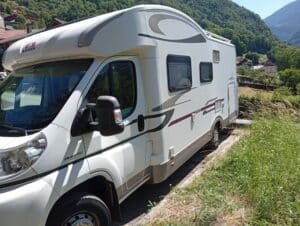 Camping-car blanc stationné en village de montagne