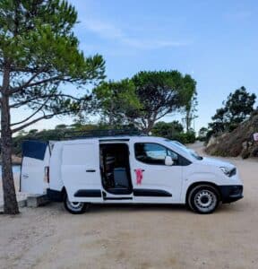 Fourgon blanc aménagé garé près de la mer