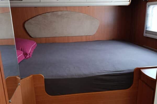 Chambre de camping-car avec lit double et rangements