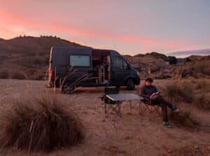Van aménagé au coucher du soleil, lecture camping