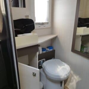 Petite salle de bain avec toilettes et rangements