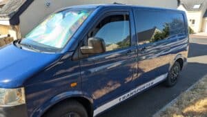 Fourgon Volkswagen Transporter bleu stationné en rue