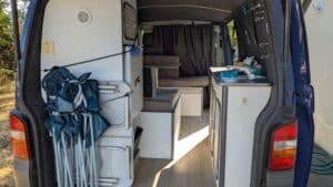 Intérieur aménagé d’un van avec kitchenette et banquettes