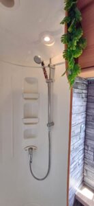 Cabine de douche moderne avec pommeau et étagères intégrées