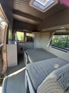 Intérieur de van aménagé avec lits et kitchenette