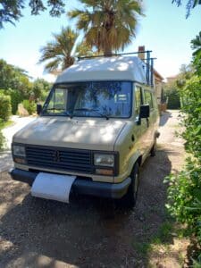 Fourgon Peugeot stationné dans jardin ensoleillé