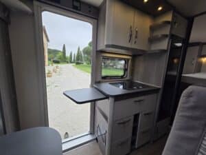 Cuisine de camping-car ouverte sur jardin verdoyant