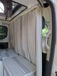 Rideau rayé séparant cabine et espace couchage van