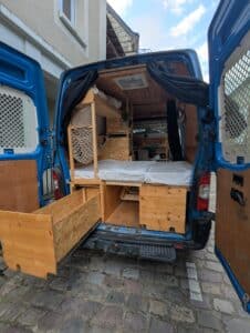 Intérieur van aménagé avec lit et rangements bois