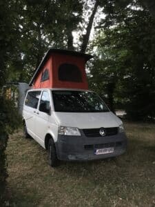 Van blanc avec tente de toit rouge
