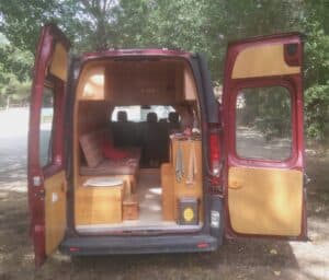 Intérieur aménagé d’un van rouge en forêt