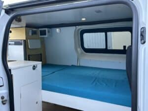 Intérieur de van aménagé avec lit et kitchenette