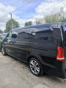 Van noir stationné dans une rue résidentielle