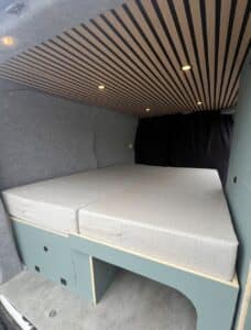 Aménagement van avec lit et rangements intégrés