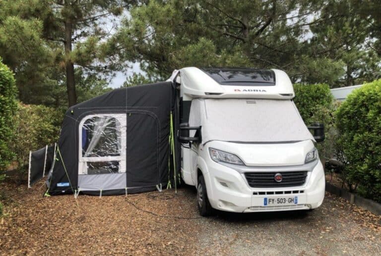 Camping-car blanc avec auvent gonflable au camping