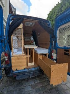 Intérieur de van aménagé en bois avec lit