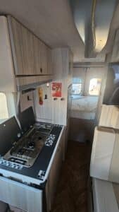 Intérieur de van aménagé avec kitchenette et lit