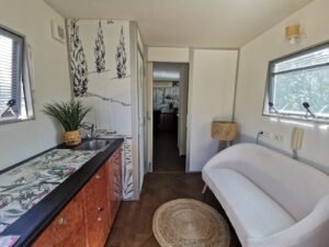 Petit salon moderne avec kitchenette et canapé blanc