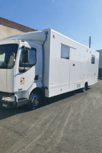 Camion blanc aménagé stationné en plein soleil