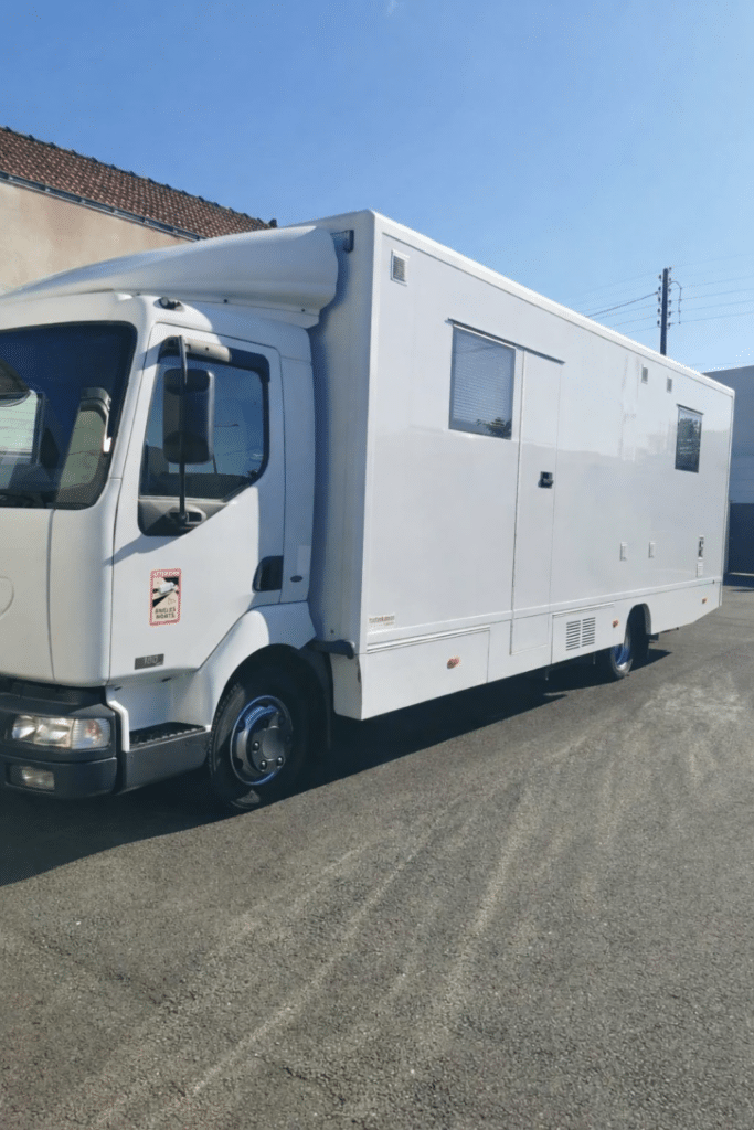 Camion blanc aménagé stationné en plein soleil
